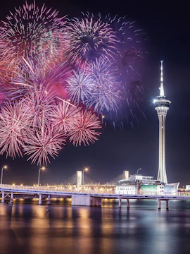 Fireworks over Macau Tower and bridge at night, Macau, China.