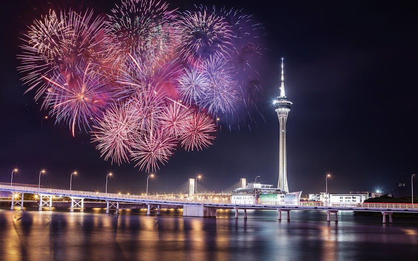 Fireworks over Macau Tower and bridge at night, Macau, China.