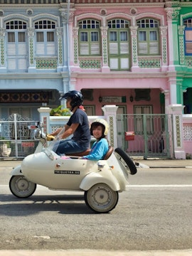Sidecar tour passing colorful shophouses in Singapore.