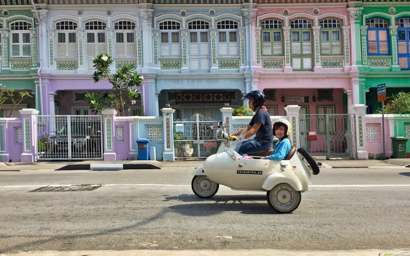 Sidecar tour passing colorful shophouses in Singapore.
