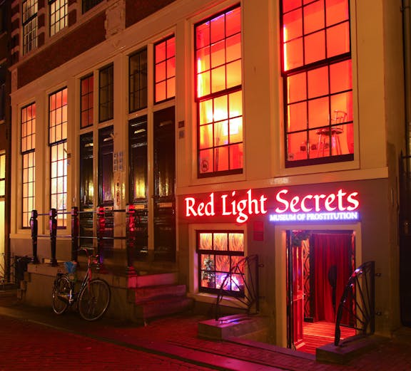 Red Light Secrets Museum entrance in Amsterdam's Red Light District at night.