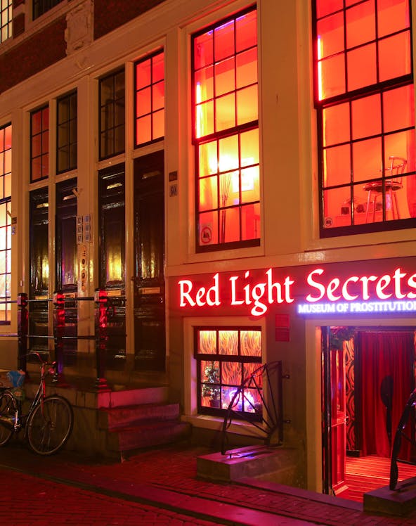 Red Light Secrets Museum entrance in Amsterdam's Red Light District at night.