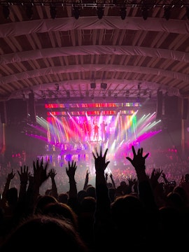 Concert crowd enjoying a vibrant light show in a Bucharest nightclub.