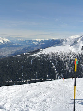 Skiers on snowy slopes with view of Innsbruck and surrounding mountains, Tux region.