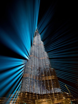 Burj Khalifa illuminated with blue lights at night, Dubai family fun experience.