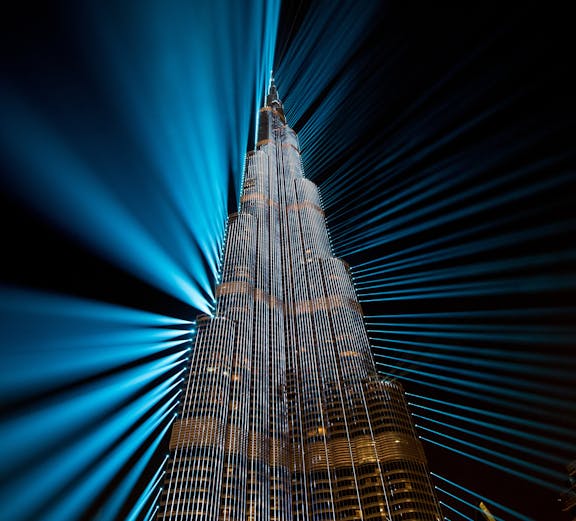 Burj Khalifa illuminated with blue lights at night, Dubai family fun experience.