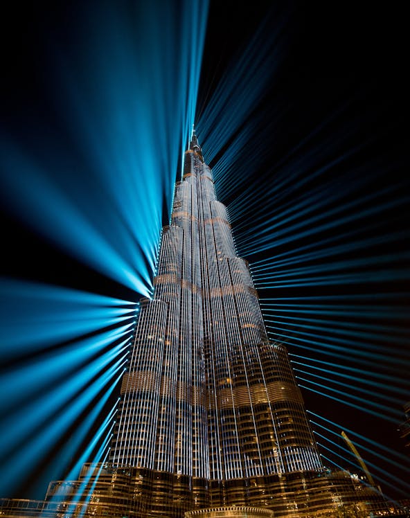 Burj Khalifa illuminated with blue lights at night, Dubai family fun experience.
