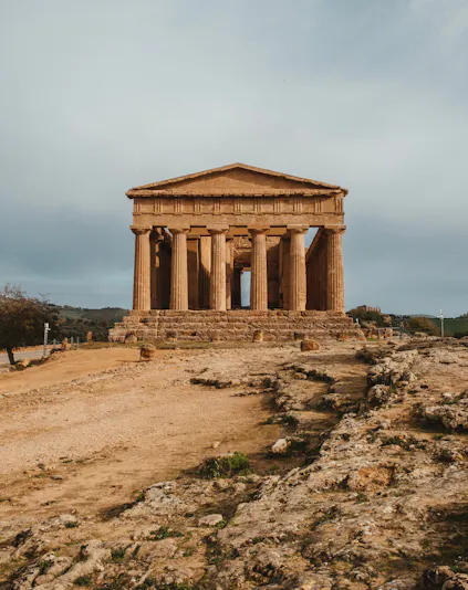 Ancient Greek temple ruins in Valle dei Templi, Sicily, with surrounding landscape.