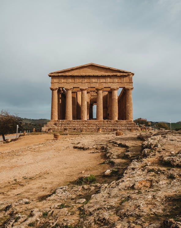 Ancient Greek temple ruins in Valle dei Templi, Sicily, with surrounding landscape.