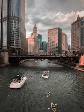 Boats and kayaks on the Chicago River with city skyscrapers in the background.