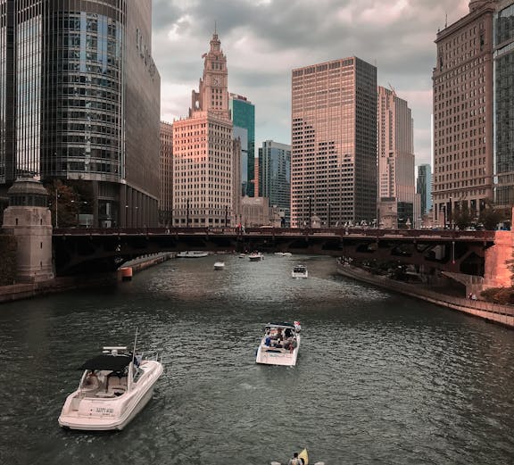 Boats and kayaks on the Chicago River with city skyscrapers in the background.