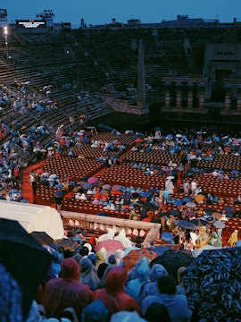 Crowd with umbrellas at Arena di Verona opera event in Verona, Italy.