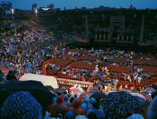 Crowd with umbrellas at Arena di Verona opera event in Verona, Italy.