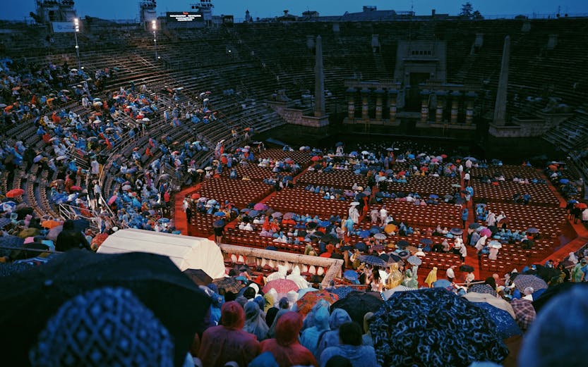 Crowd with umbrellas at Arena di Verona opera event in Verona, Italy.