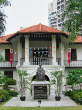 Sun Yat Sen Nanyang Memorial Hall in Singapore with statue and flags.
