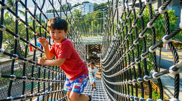 Children playing on a rope bridge at Nestopia, Singapore.