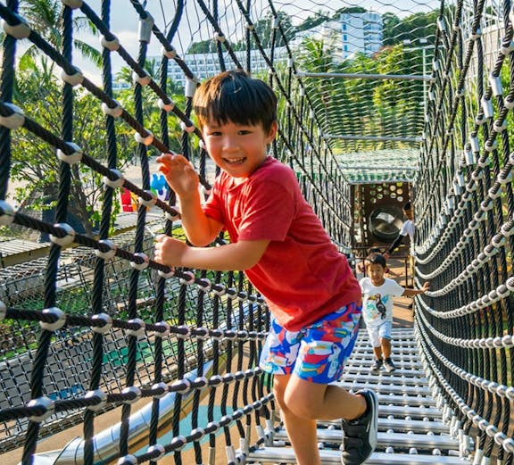 Children playing on a rope bridge at Nestopia, Singapore.