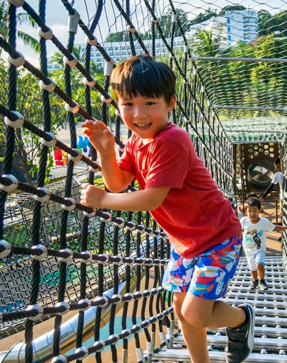 Children playing on a rope bridge at Nestopia, Singapore.