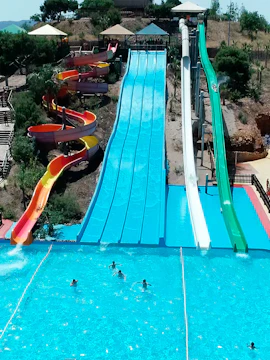 Water park slides and pools in Murcia, Spain, with people enjoying the attractions.