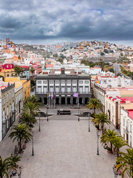 Plaza de Santa Ana in Las Palmas, Gran Canaria, with colorful buildings and distant hills.
