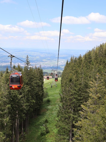 Cable cars over forested hills on Zurich to Lucerne tour route.