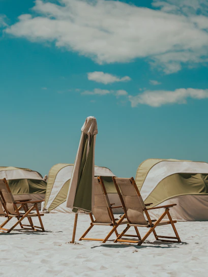 Beach chairs and umbrellas on Clearwater Beach, Florida, with tents in the background.