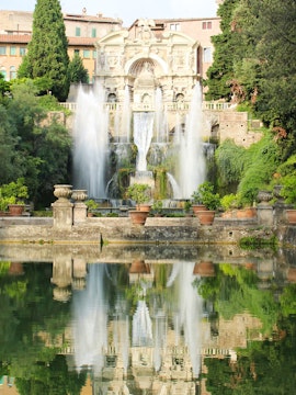 Villa d'Este fountains and gardens in Tivoli, Italy, reflecting in a tranquil pool.
