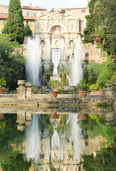 Villa d'Este fountains and gardens in Tivoli, Italy, reflecting in a tranquil pool.