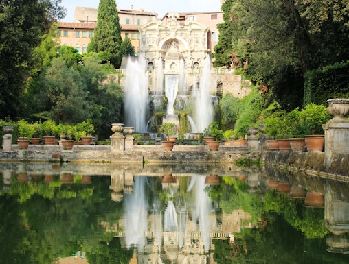 Villa d'Este fountains and gardens in Tivoli, Italy, reflecting in a tranquil pool.