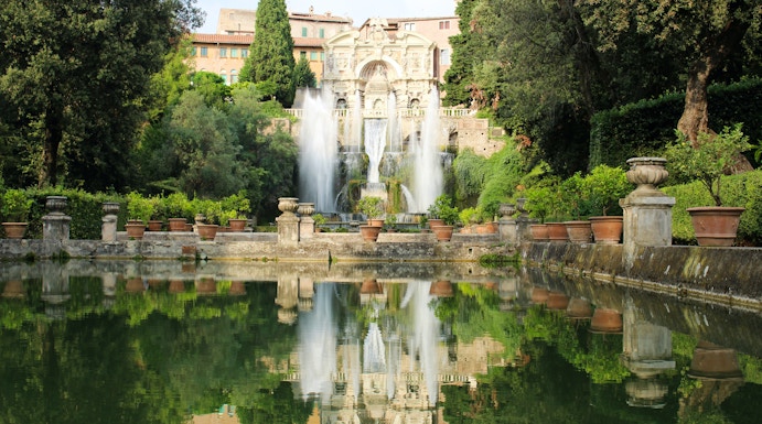 Villa d'Este fountains and gardens in Tivoli, Italy, reflecting in a tranquil pool.