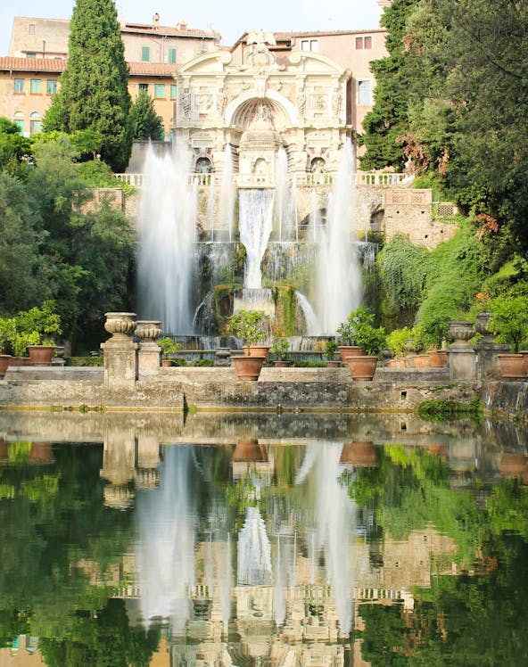 Villa d'Este fountains and gardens in Tivoli, Italy, reflecting in a tranquil pool.