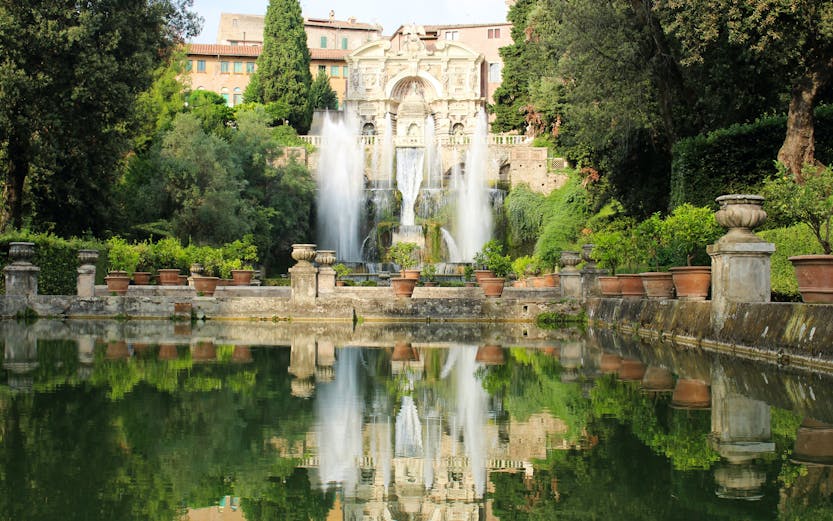 Villa d'Este fountains and gardens in Tivoli, Italy, reflecting in a tranquil pool.