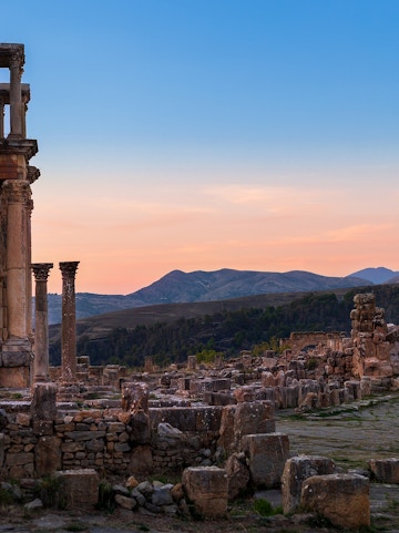 Ancient ruins with columns at sunset, resembling Baths of Caracalla.