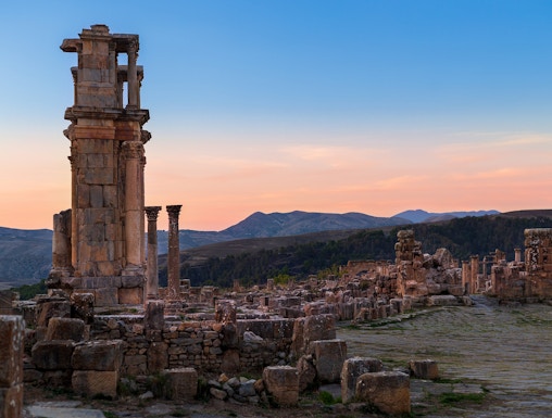 Ancient ruins with columns at sunset, resembling Baths of Caracalla.