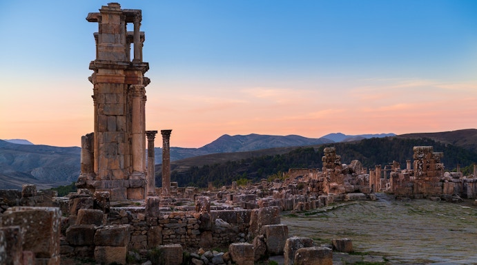Ancient ruins with columns at sunset, resembling Baths of Caracalla.