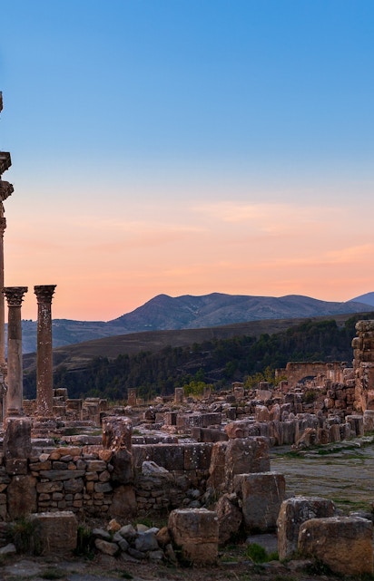 Ancient ruins with columns at sunset, resembling Baths of Caracalla.