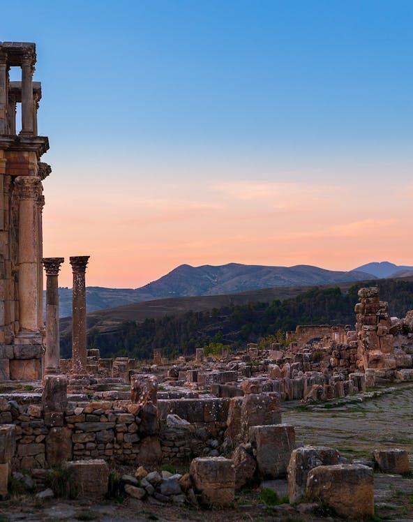 Ancient ruins with columns at sunset, resembling Baths of Caracalla.