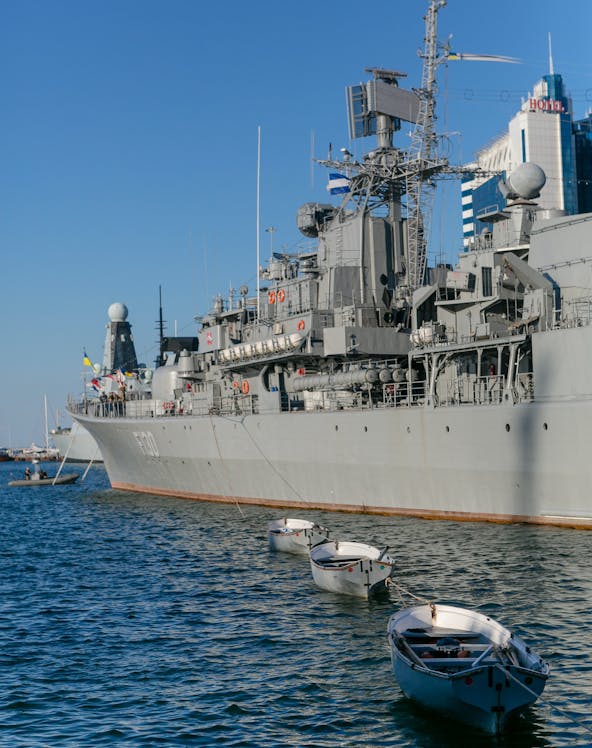 Battleship docked with small boats in the water, HMS Belfast tour.