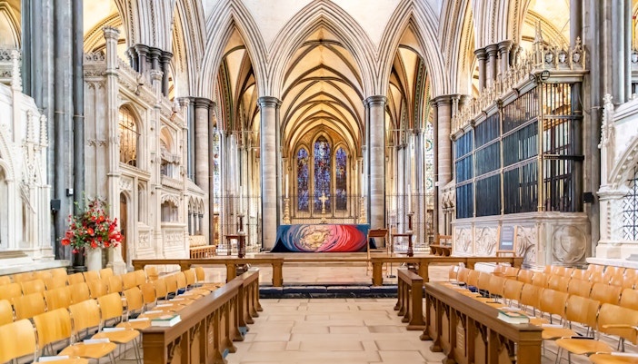 Salisbury Cathedral interior with vaulted arches and stained glass windows.