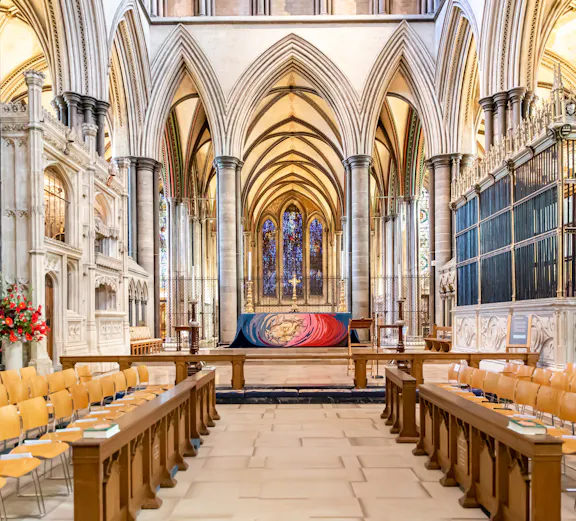 Salisbury Cathedral interior with vaulted arches and stained glass windows.