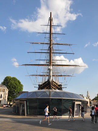 Cutty Sark ship in Greenwich, London, with visitors walking nearby.