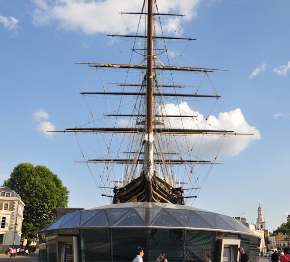 Cutty Sark ship in Greenwich, London, with visitors walking nearby.