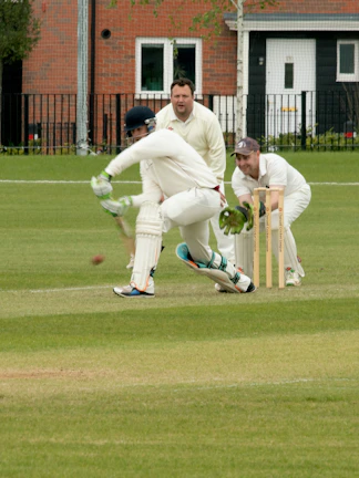 Cricketer batting at Kia Oval Cricket Ground with wicketkeeper and fielder.