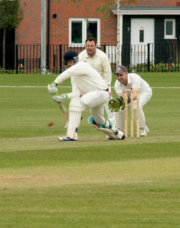 Cricketer batting at Kia Oval Cricket Ground with wicketkeeper and fielder.