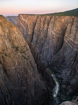 Black Canyon cliffs with river below at sunset, Colorado.