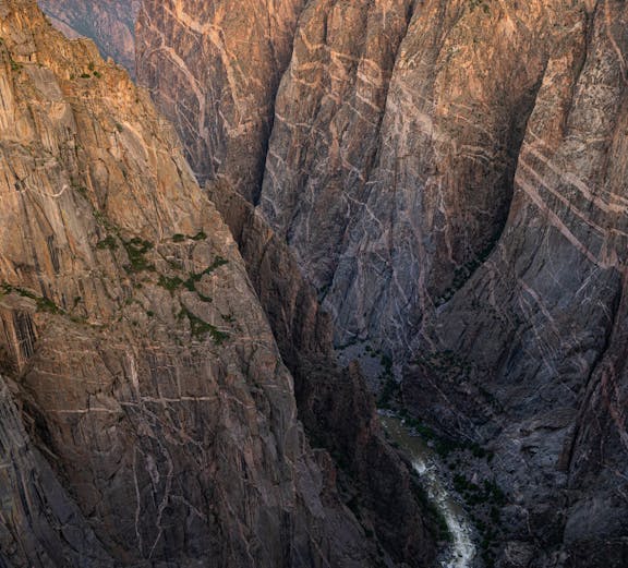 Black Canyon cliffs with river below at sunset, Colorado.