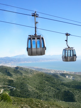 Benalmadena Cable Car over green hills with coastal view in Spain.