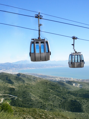 Benalmadena Cable Car over green hills with coastal view in Spain.