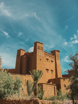 Ancient kasbah in Ouarzazate, Morocco, with clear blue sky.