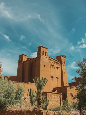 Ancient kasbah in Ouarzazate, Morocco, with clear blue sky.